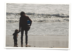 Young Photographer father and son on the pacific coast beach in ventura california